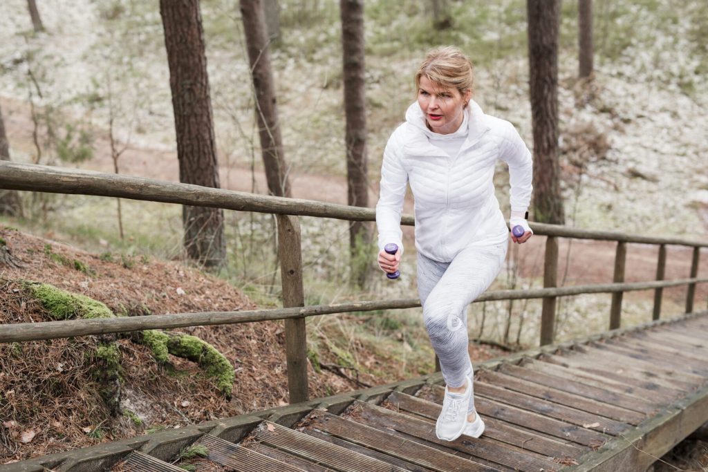 Mujer subiendo escaleras al aire libre como entrenamiento de fuerza funcional